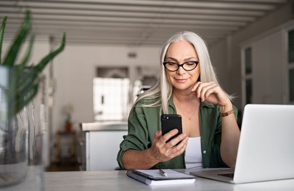 Woman with Laptop and Mobile Phone Quoting Earthquake Insurance